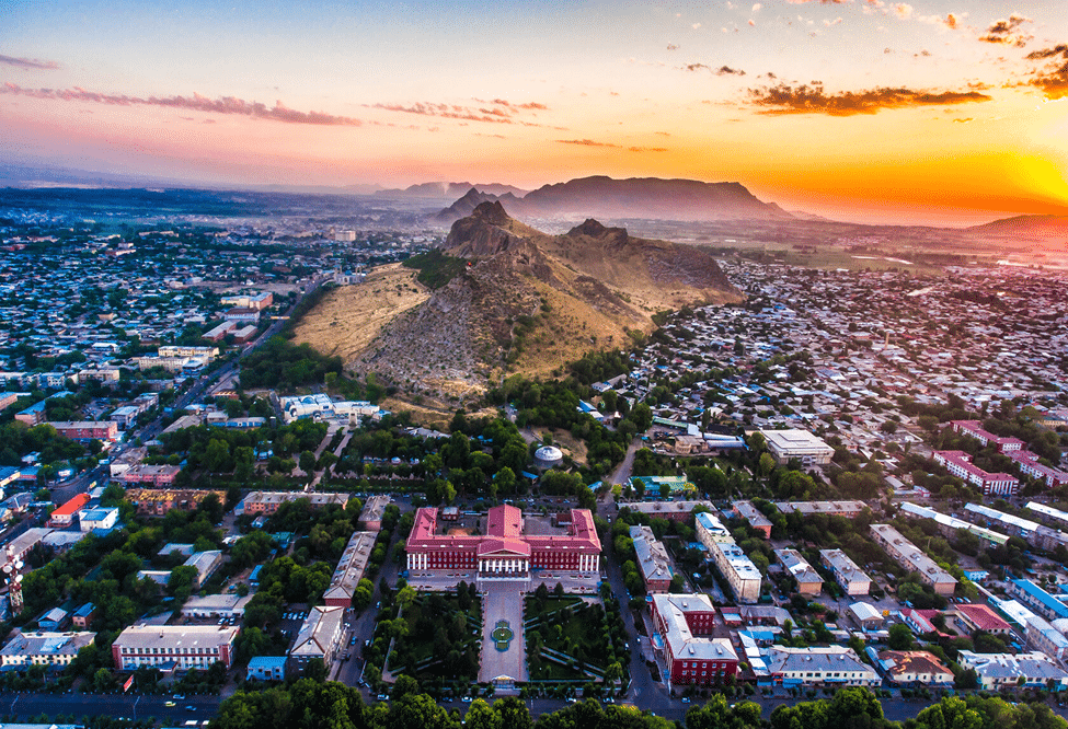 Sonnenuntergang über Osch mit Suleiman-Too-Berg und weitem Stadtpanorama